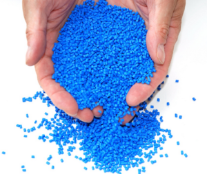 Two hands full of blue masterbatch plastic resins with VCI corrosion prevention