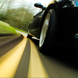 Left rear tire view of car traveling down the road