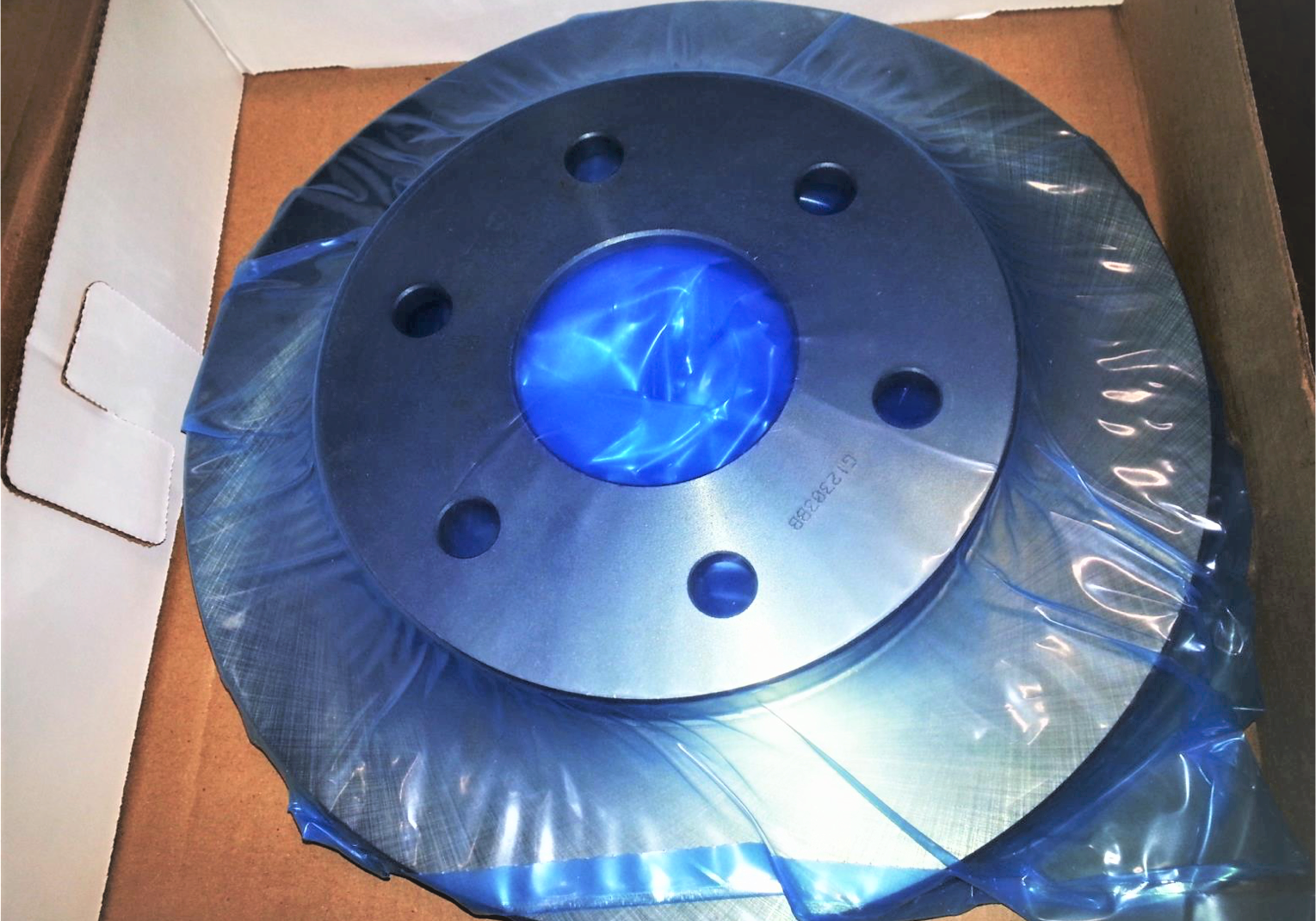 Car part in box wrapped in blue VCI film