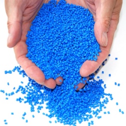 Two hands full of blue masterbatch plastic resins with VCI corrosion prevention